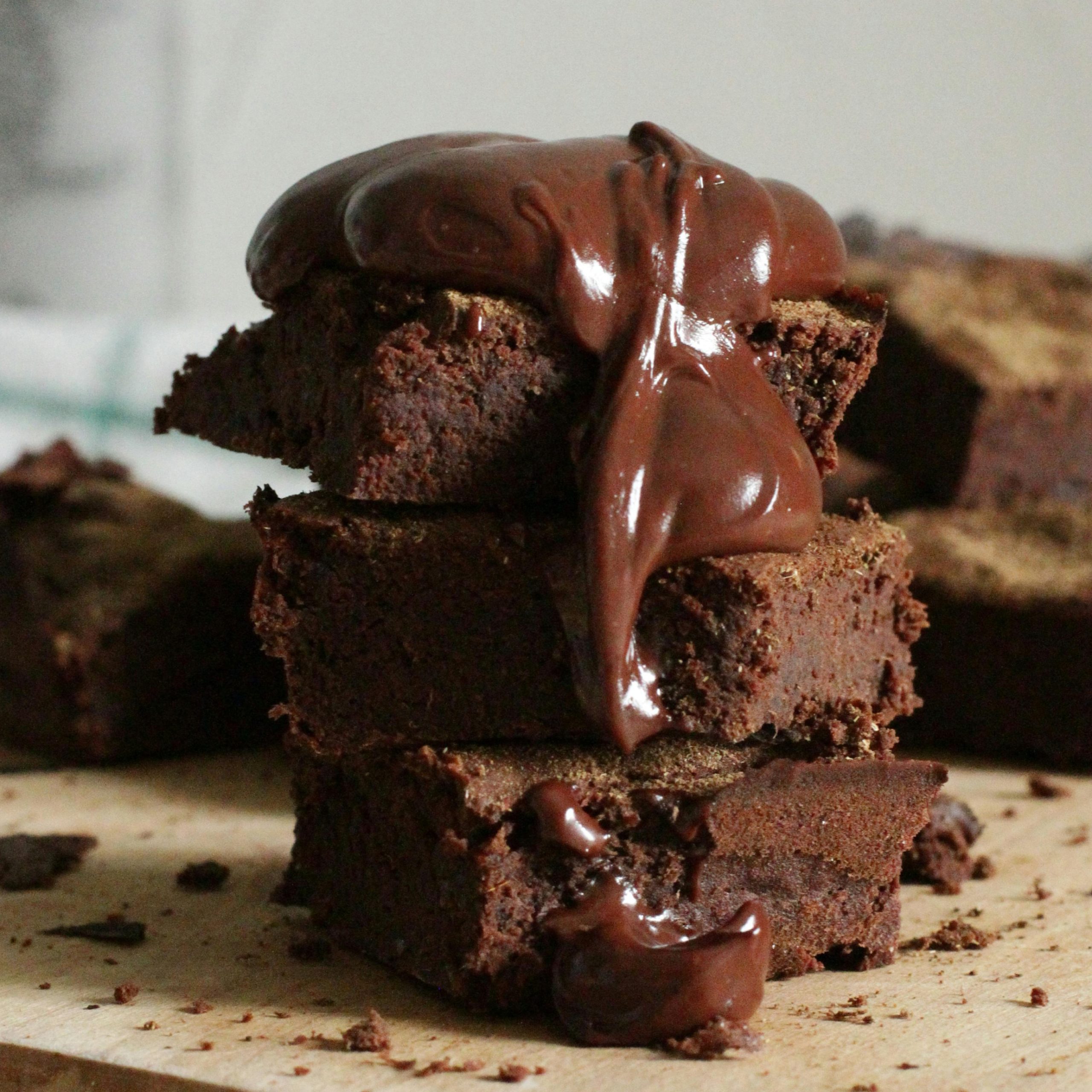 Gestapelte saftige Schokoladen-Brownies, die reichhaltig mit geschmolzener Schokoladensauce übergossen werden