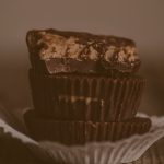 Gestapelte gefüllte Schokoladen-Cups, wobei der oberste Cup angebissen ist und die cremige Füllung zeigt